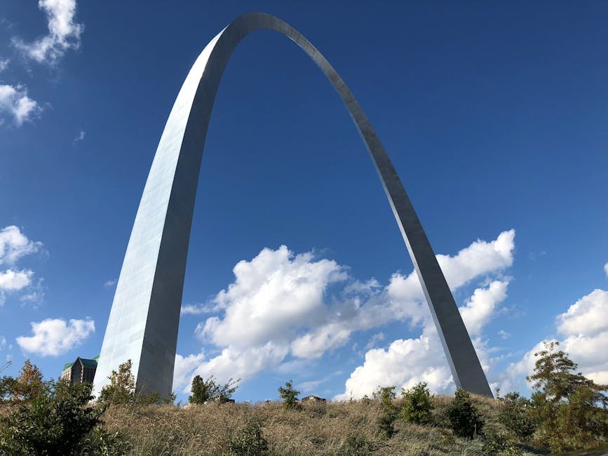 Stunning view of the Gateway Arch in St. Louis, Missouri, against a bright blue sky with clouds.