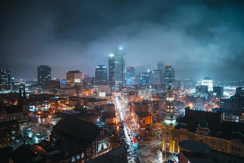 Stunning nighttime view of the Indianapolis skyline with illuminated skyscrapers and a bustling street below.