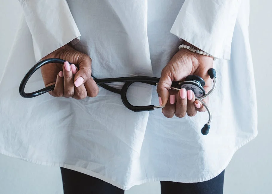 A medical professional holding a stethoscope in a clinical setting.