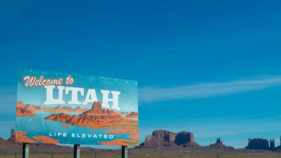 Scenic view of Utah welcome sign against desert and blue sky backdrop.